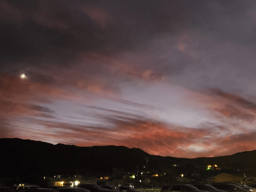 A photo of a sunset with dark pinks and blues. 